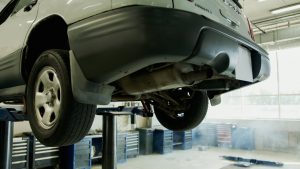 A vehicle elevated on a lift in an auto repair shop, ready for service.